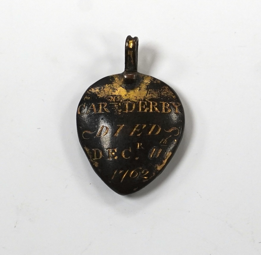 An 18th century gilt metal heart shaped mourning pendant, with engraved inscription, 'CARna DERBY DIED DEC 11th, 1762' and plaited hair beneath a glazed panel verso, 27mm.